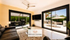 Helles Wohnzimmer der Luxusvilla in Cala Murada mit Ledersofas, Deckenventilator und großen Schiebetüren zur Terrasse.