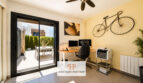 Modernes Heimarbeitszimmer der Bauhausvilla in Cala Murada mit Glasschiebetür zur sonnigen Terrasse und Fahrrad-Wanddeko.
