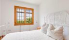 Helles Schlafzimmer mit großformatigen Holzfenstern und Heizkörper