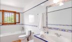 Helles Badezimmer mit Wanne, Dusche und großformatigen Holzfenstern