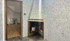 Gefliester Raum mit Eckkamin in renovierungsbedürftiger Stadthauswohnung, Manacor