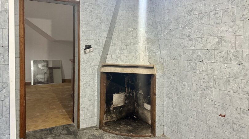 Gefliester Raum mit Eckkamin in renovierungsbedürftiger Stadthauswohnung, Manacor