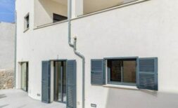 Außenansicht Stadthaus Artà: helle Fassade, blaue Fensterläden, Terrasse, moderner Baustil auf Mallorca