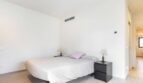 Helles Schlafzimmer mit Doppelbett, schwarzen Nachttischen und modernem Design im Stadthaus Artà
