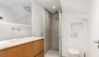 Modernes Badezimmer mit Holzwaschtisch, Glasdusche und Wand-WC im Stadthaus Artà