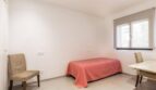 Helles Schlafzimmer mit Einzelbett, zwei Stühlen und Schreibtisch im Stadthaus Artà, Mallorca.