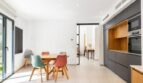 Helles Esszimmer mit bunten Stühlen und moderner grauer Einbauküche in stilvollem Stadthaus in Artà