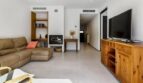 Helles Wohnzimmer mit Ledersofa, Kamin, Holzregal und TV-Schrank in stilvollem Stadthaus in Artà