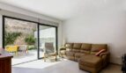 Helles Wohnzimmer mit Ledersofa, Glasschiebetür und sonniger Terrasse im Stadthaus in Artà