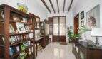 Entrance area with wooden shelves full of family photos, a wooden beam ceiling, and a rustic front door in Felanitx.