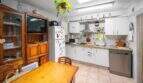 Kitchen-living room with a wooden table, white built-in cabinets, a refrigerator, and a dishwasher in the house in Felanitx