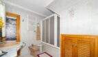 Bright bathroom with a shower stall, bidet, wooden cabinet, and white tiles in the house in Felanitx.