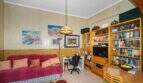 Living room with a red sofa, bookshelf, TV, and Tiffany pendant lamp in a charming house in Felanitx