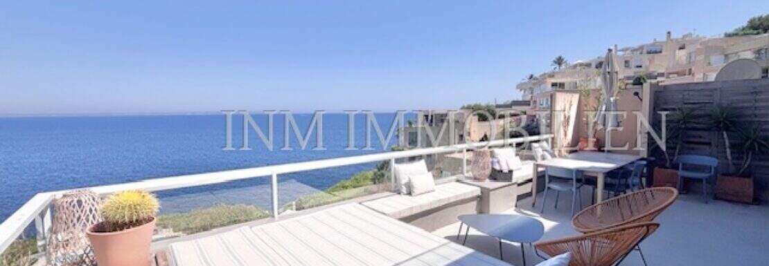 Sunny rooftop terrace with a lounge area, dining table, and direct ocean view in Cala Vinyes, Calvià