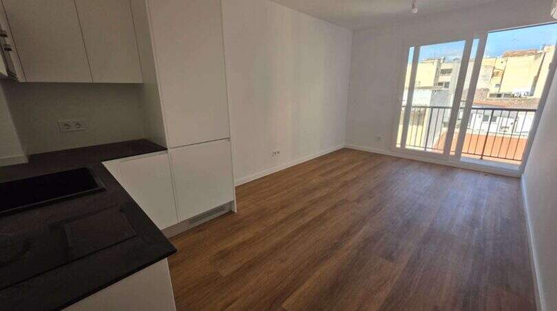 _Wohnzimmer mit offner Küche und Zugang zum Balkon