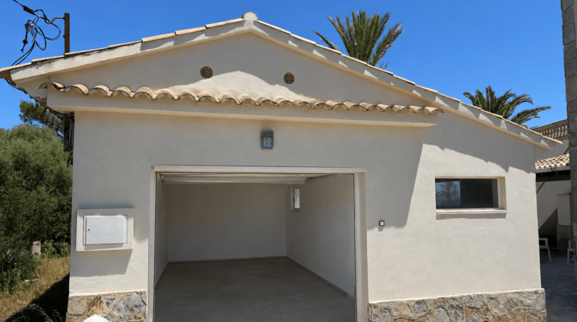 Detached garage building of the Majorcan villa in Manacor with Mediterranean tile roof and natural stone cladding