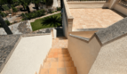 Terrace stairs with sandstone tiles, balustrade and sea view of a Majorcan villa in Manacor