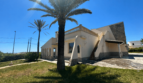 Exterior view of a Majorcan villa in Manacor with palm trees, balustrade, outdoor staircase and Mediterranean garden in brilliant sunshine.