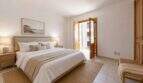 Helles Schlafzimmer der Maisonette in Porto Cristo mit Doppelbett, Holzmöbeln und Balkonzugang zum Meer.
