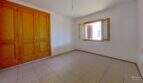 Helles Schlafzimmer der Maisonette in Porto Cristo mit Einbauschrank aus Holz und Fenster zum Innenhof