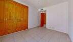 Helles Schlafzimmer der Maisonette in Porto Cristo mit großem Holzeinbauschrank und roter Tür