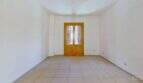 Leerer heller Wohnraum mit Fliesenboden und zweiflügeliger Holztür mit Fensterläden in Maisonette Porto Cristo