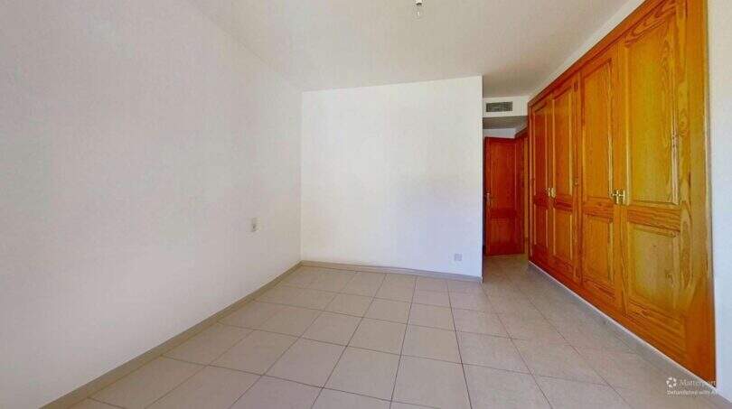 Leeres Schlafzimmer mit Einbauschrank aus Holz und Fliesenboden in Maisonette Porto Cristo