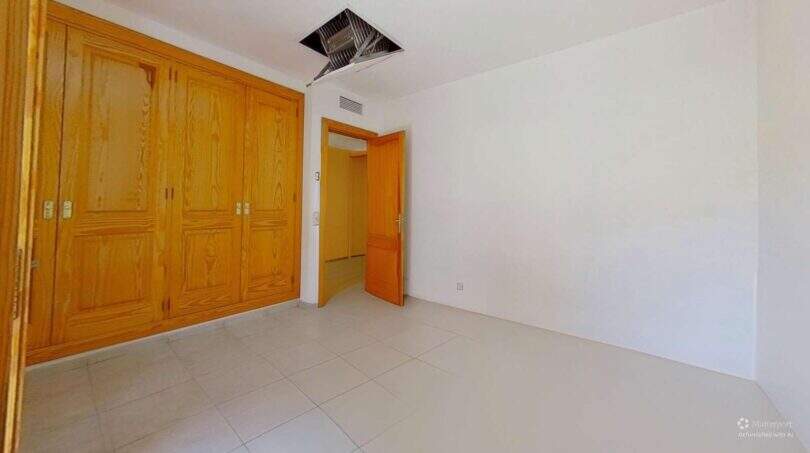 Helles Schlafzimmer der Maisonette in Porto Cristo mit Einbauschrank aus Holz und Fliesenboden
