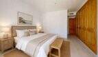 Helles Schlafzimmer der Maisonette in Porto Cristo mit Doppelbett, Holzschränken und neutralem Dekor