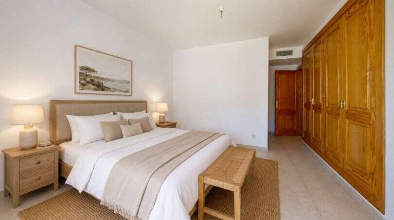 Helles Schlafzimmer der Maisonette in Porto Cristo mit Doppelbett, Holzschränken und neutralem Dekor