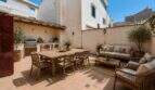 Sonnige Terrasse mit Outdoor-Küche, Esstisch und Lounge-Bereich der Maisonette in Porto Cristo