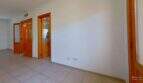 Leerer Flur der Maisonette in Porto Cristo mit Fliesenböden, weißen Wänden und drei Holztüren mit Glasfenstern