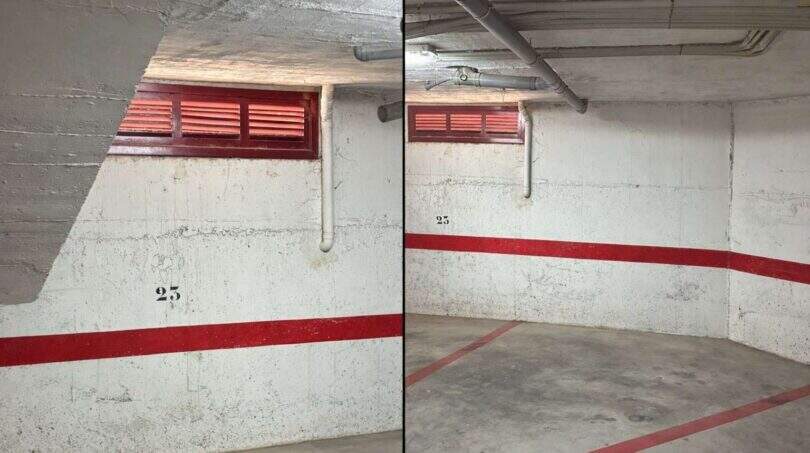 Tiefgarage Nr. 25 in Maisonette Porto Cristo, Betonwände mit rotem Streifen, Lüftungsschlitze, Rohre an Decke.