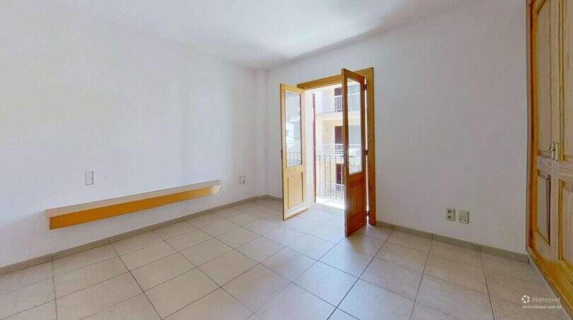 Helles leeres Zimmer mit Fliesenboden, Holztür zum Balkon und Meerblick in Maisonette Porto Cristo