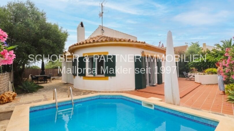 Einfamilienhaus in Cala Murada mit blauem Pool, Terrasse und mediterranem Garten mit Bougainvillea.