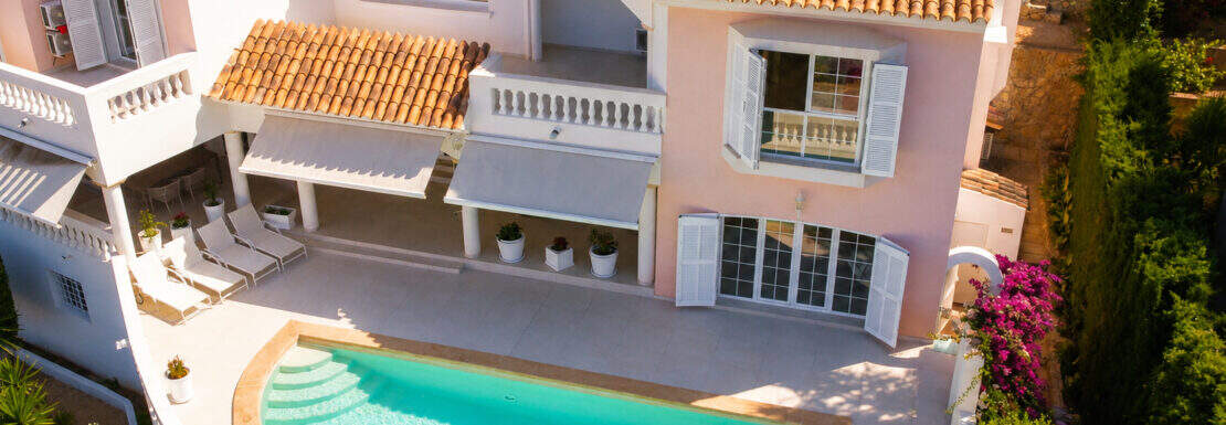 Luxusvilla Camp de Mar: Luftaufnahme mit Pool, Terrasse, rosa Fassade und mediterranem Garten.