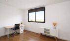 Modernes Arbeitszimmer mit Holzboden, Schreibtisch, ergonomischem Stuhl und Fenster mit Stadtblick in Palma