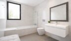 Modernes Badezimmer mit Badewanne, Dusche, WC und schwebender Waschtischeinheit in hellem Design.