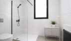 Modernes weißes Badezimmer mit bodenebener Dusche, schwarzen Armaturen und eleganten Wellenstruktur-Fliesen.