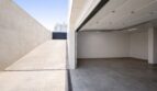 Leere Doppelgarage mit Betonboden und Einfahrtsrampe eines modernen Einfamilienhauses in Palma de Mallorca.