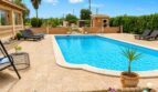 Privater Pool mit Sonnenliegen und Palmen der Finca in Sencelles, umgeben von mediterranem Grün.
