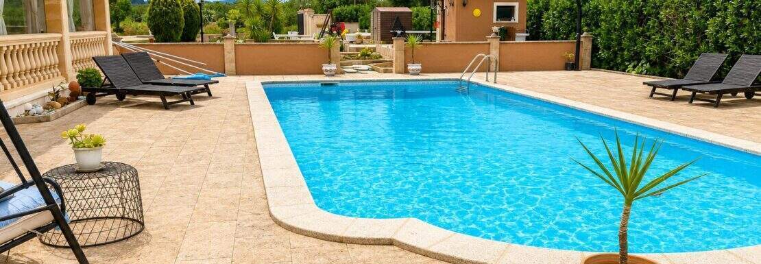 Privater Pool mit Sonnenliegen und Palmen einer Finca in Sencelles, umgeben von gepflegtem Garten.