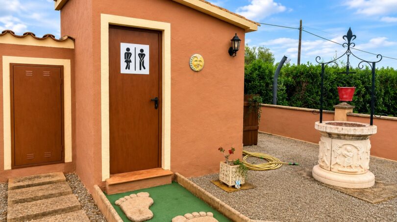 Rustikale Außentoilette mit Miniaturputt-Anlage, Steinbrunnen und mediterranem Flair in Sencelles.