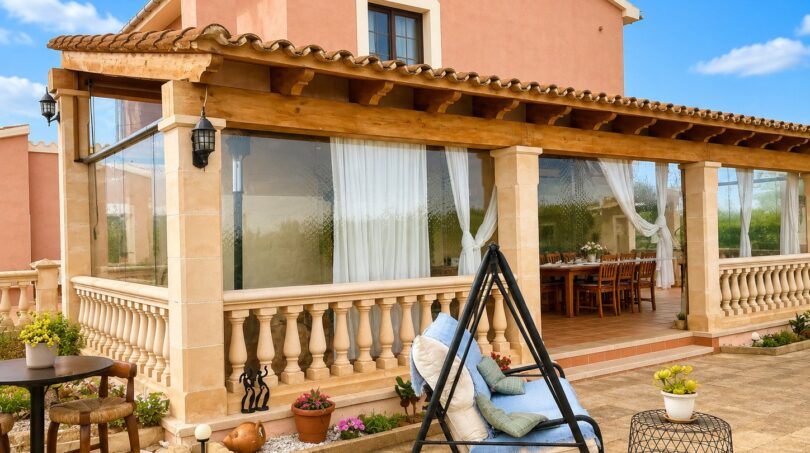 Sonnige Terrasse mit Schaukelsessel, Pool und überdachtem Essbereich einer Landfinca in Sencelles.