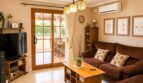Helles Wohnzimmer mit brauner Couch, Holztisch und Glasschiebetür zur Terrasse in Sencelles.