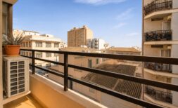 Sunny balcony with city view, dark railing and air conditioning in Palma de Mallorca