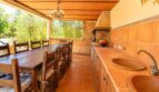 Überdachte Terrasse der Finca mit Grillküche, Doppelwaschbecken und großem Holzesstisch für 8 Personen.