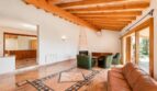 Wohnzimmer der Finca in Marratxí mit Holzbalkendecke, Marmorboden, Kamin und Ledersofas