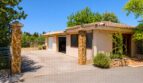 Außenansicht der Finca in Marratxí mit Terrakotta-Ziegeldach, Natursteinpfeilern und Garagenzufahrt.