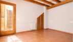 Leeres Zimmer der Finca Marratxí mit Terrakottaboden, Holzbalkendecke und Tür zum Außenbereich